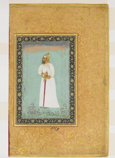 Mughal album page with a gold-flecked border framing a small portrait of a standing man in a long white robe and turban, holding a staff and a sword, against a pale green ground.