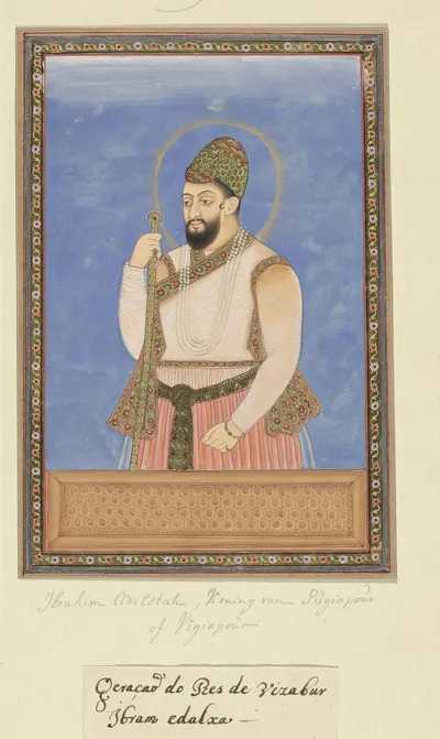 Deccani painting of a bearded king with a halo, in a jewelled turban and a white jama, standing in profile against a blue ground and holding a flower, within a decorated border.