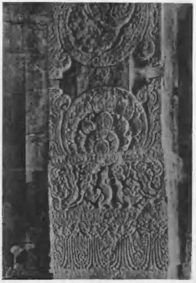 Old photograph of a stone pillar covered with large carved lotus medallions and foliage.
