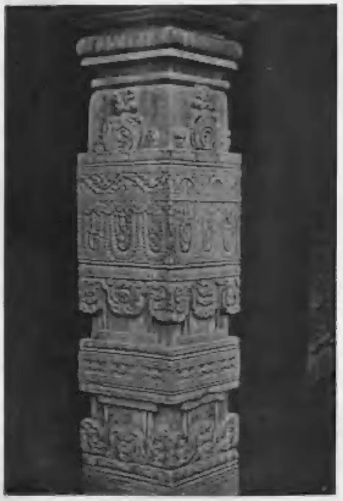 Old photograph of a square stone pillar carved with bands of floral and figure ornament.