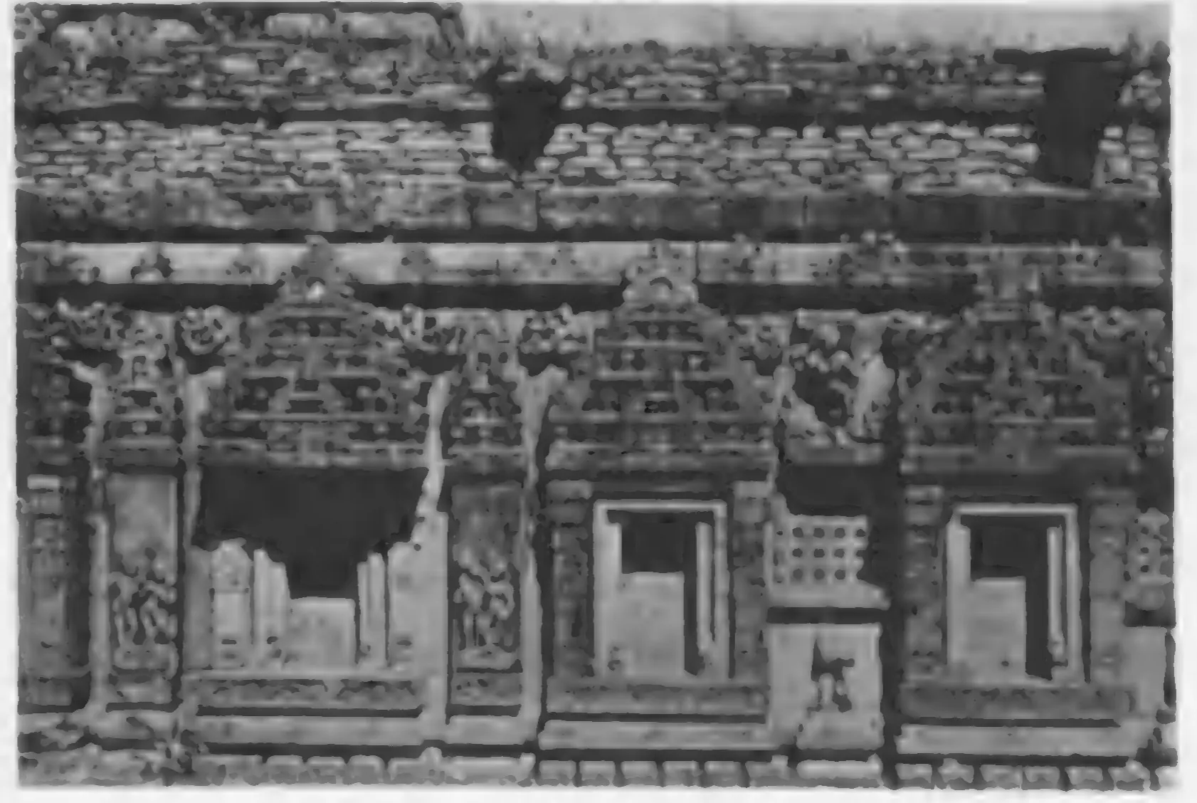 Old photograph of a temple wall with pilastered niches, small pierced windows and pediments.