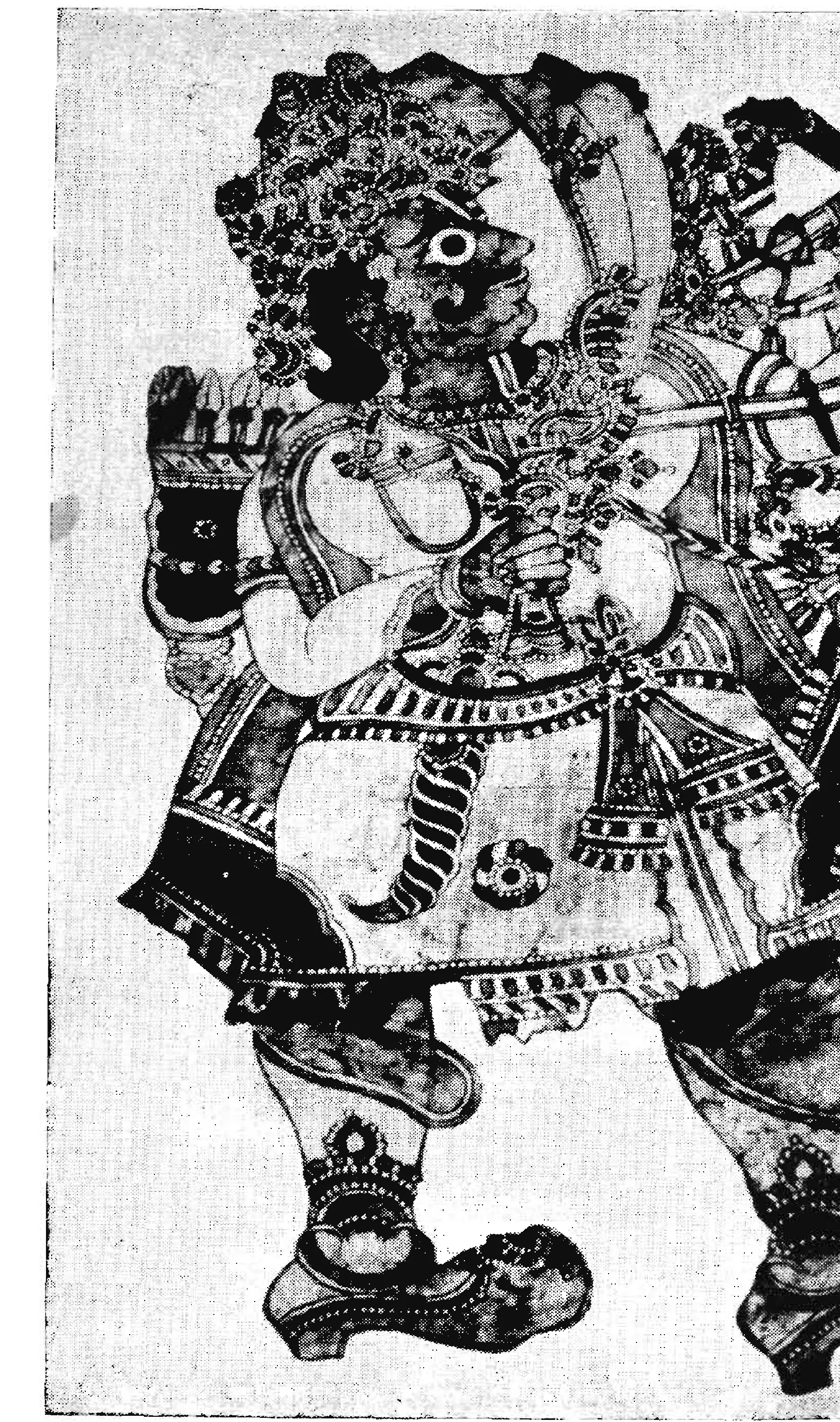 Black-and-white photograph of a large leather puppet of a crowned figure drawing a bow, with patterned clothes and jointed legs.