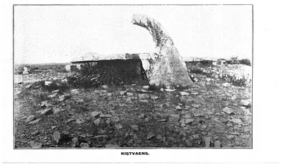 Photograph of a prehistoric stone cist: large upright and capping slabs of a burial chamber in stony ground. Printed sideways.