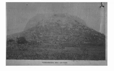 Faded photograph of a rocky hill with the fortifications of Gurramkonda along its slopes. Printed sideways.