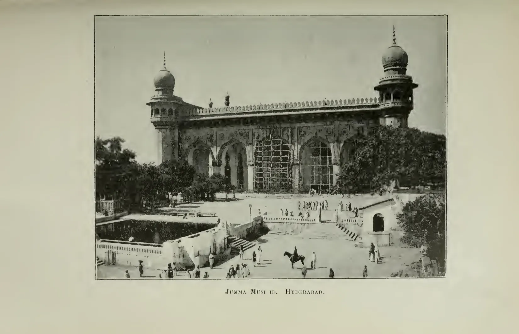 Photograph of the front of a mosque in Hyderabad with a minaret, arches and a courtyard. Printed sideways.