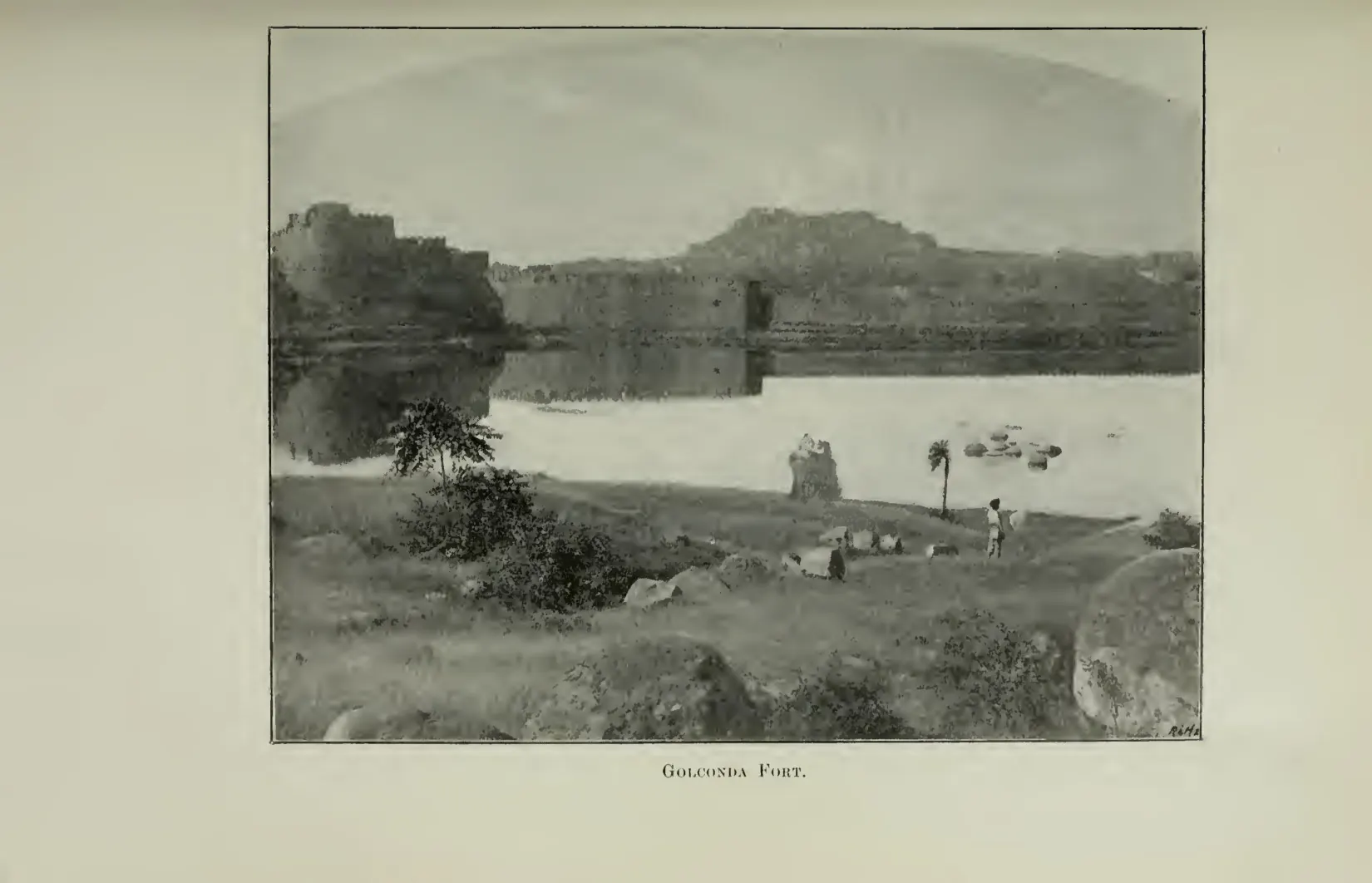 Photograph of Golconda fort on its hill seen across open ground, with walls and buildings on the slope. Printed sideways.