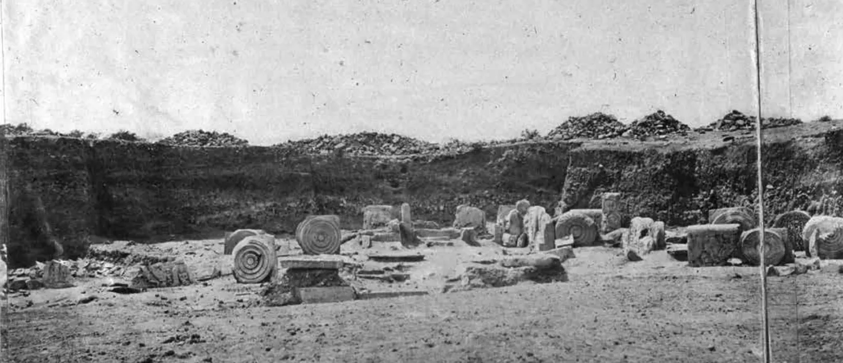1880 photograph of the excavation at the south gate of the Amaravati stupa, with carved slabs exposed in a trench.