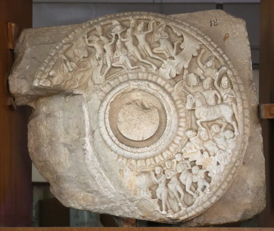 Carved limestone roundel from the Amaravati stupa, c. 150 CE, with crowded narrative relief around a central lotus, in the Government Museum, Chennai.