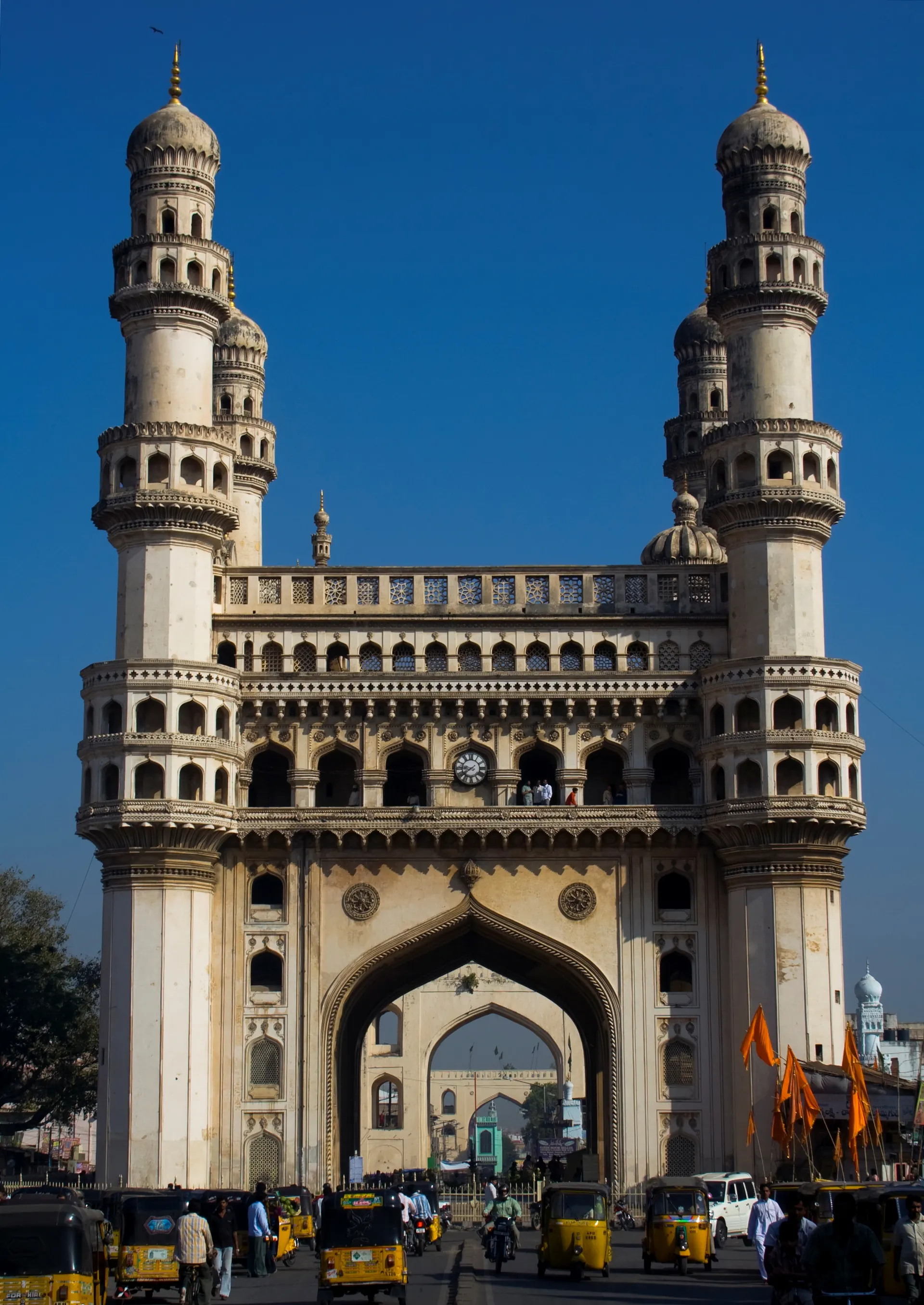 The Charminar in Hyderabad against a deep blue sky, with its four minarets and large arches.