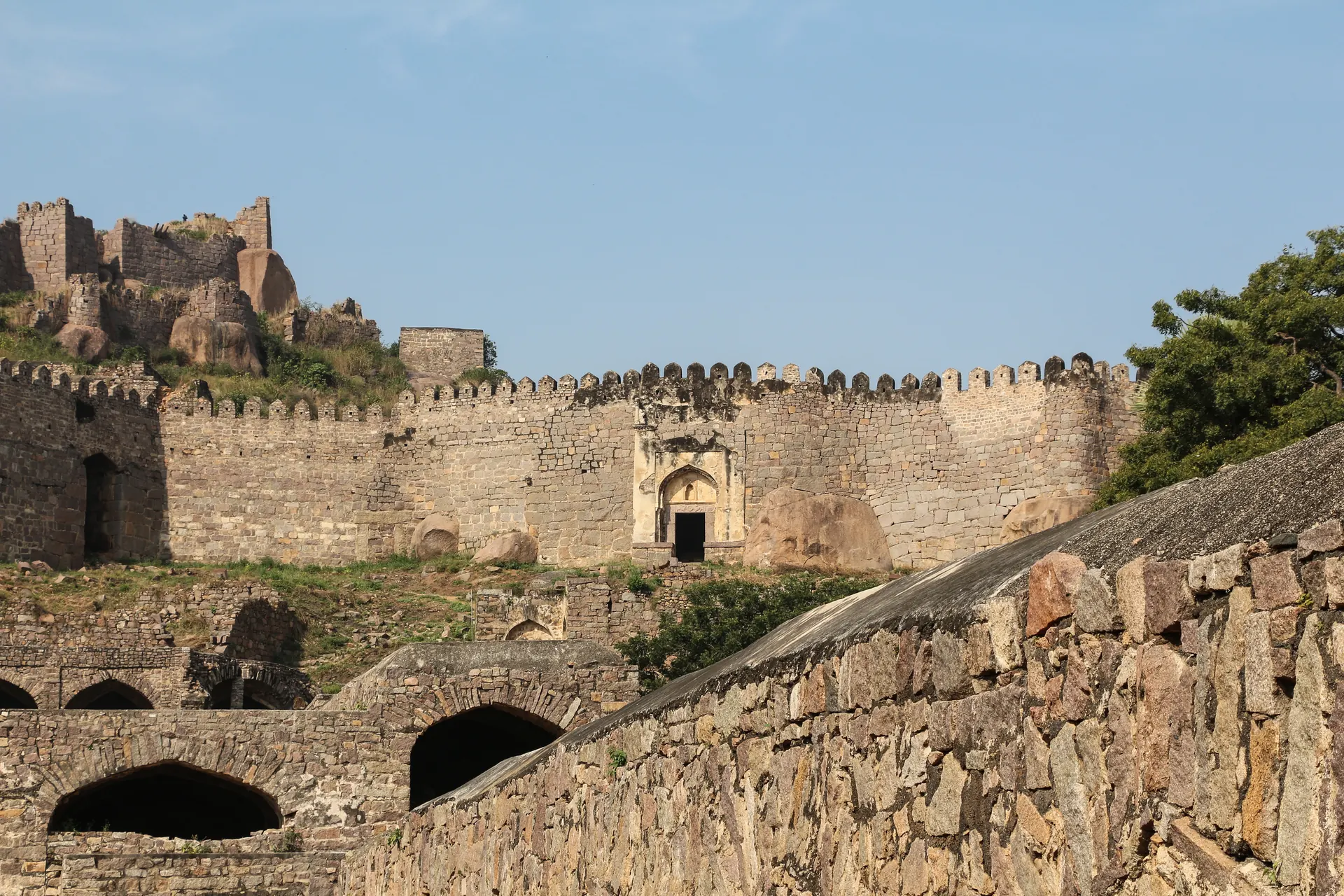 Golconda Fort's granite walls and a gate climbing toward the hilltop citadel.