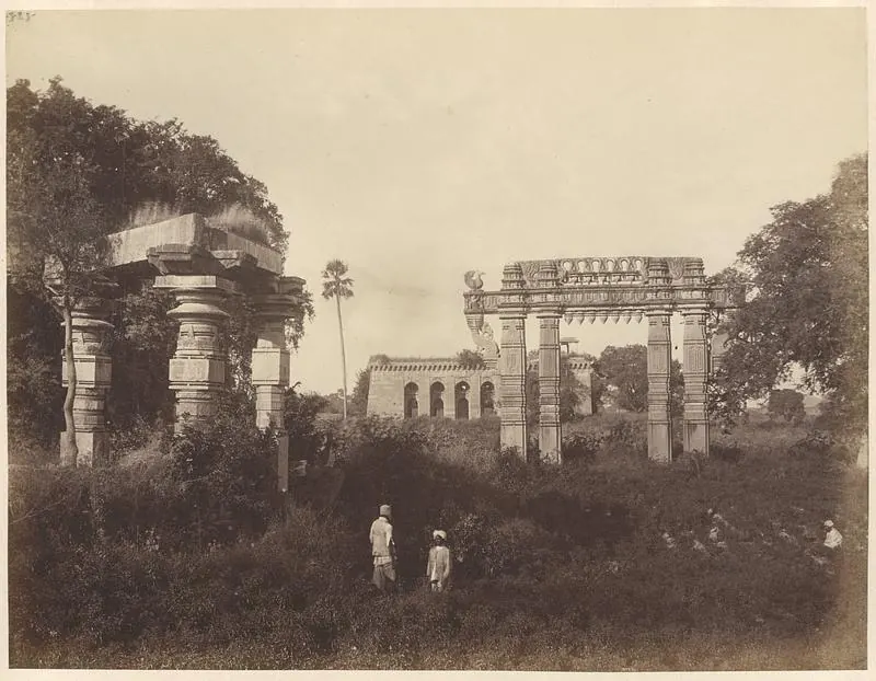 1870s photograph of a Kakatiya stone gateway and scattered temple ruins at Warangal Fort.