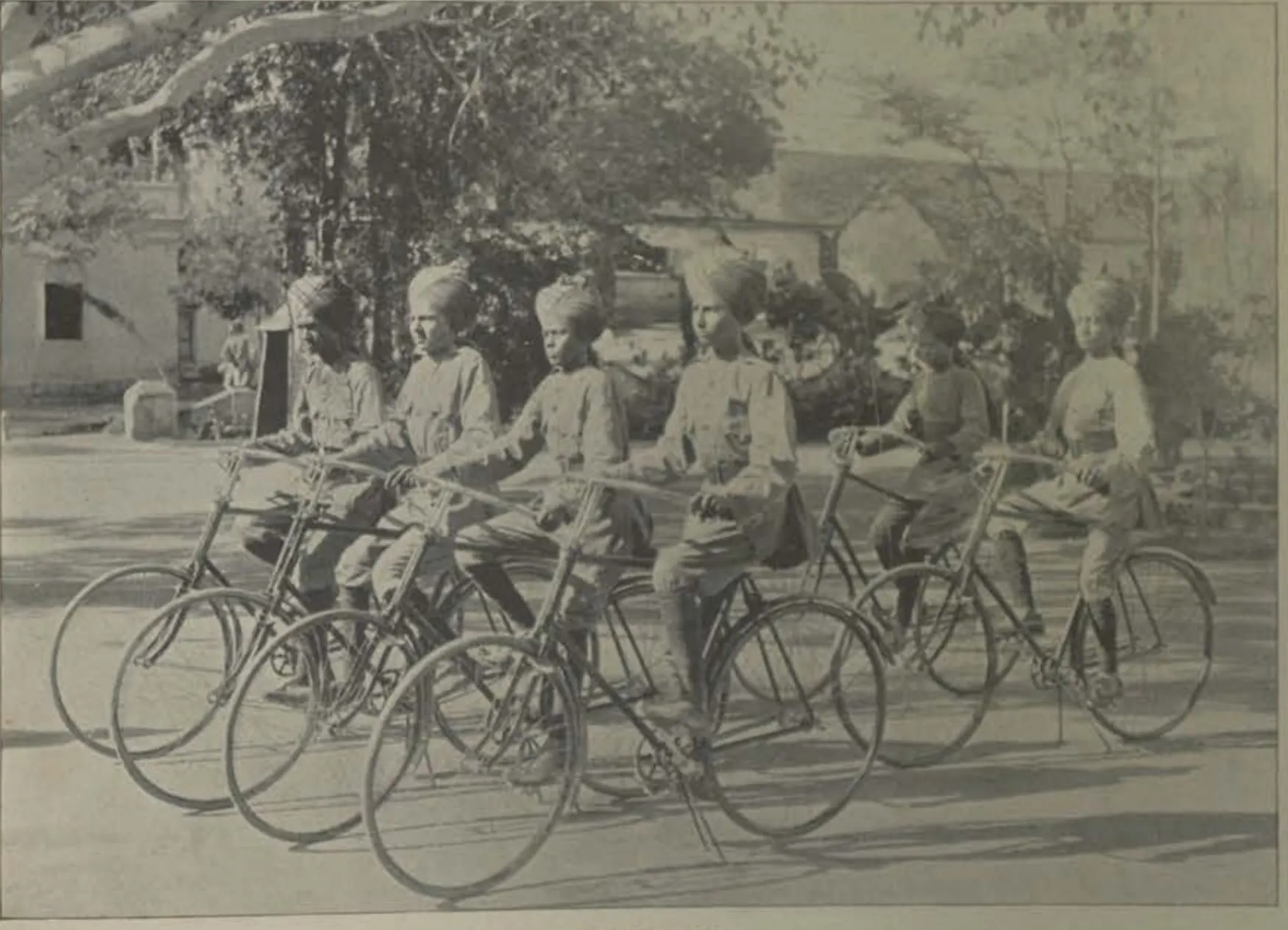 A group of young men in uniform with their bicycles.
