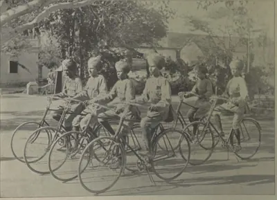 A group of young men in uniform with their bicycles.