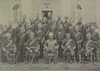 The City Kotwal and his police officers in uniform, seated and standing in front of a building.