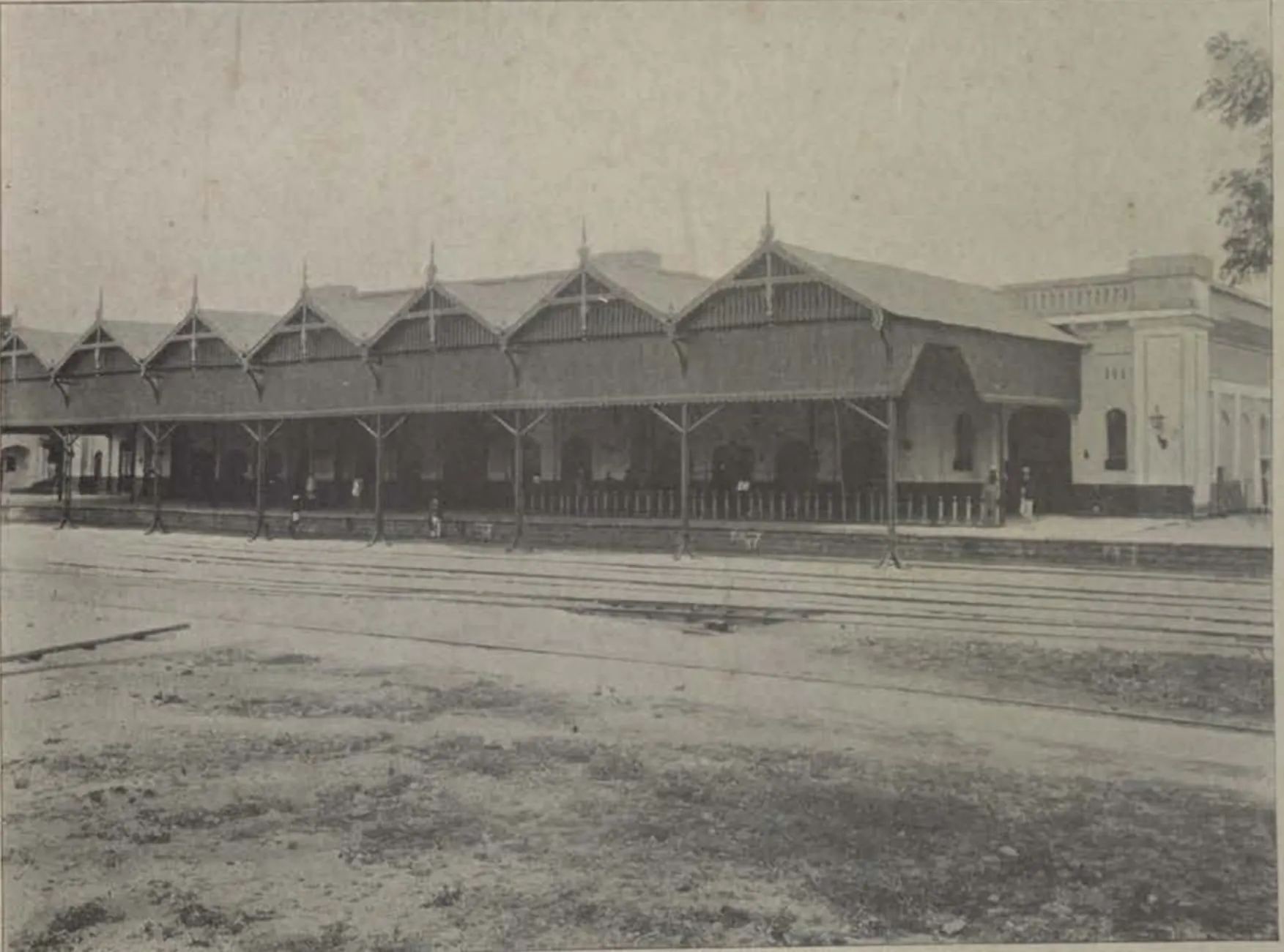 The Hyderabad railway station, a long train shed with a row of gabled roofs beside the tracks.