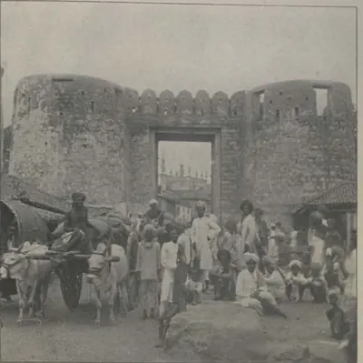 The Delhi Gate, a gateway between round bastions, with a crowd and carts in front.