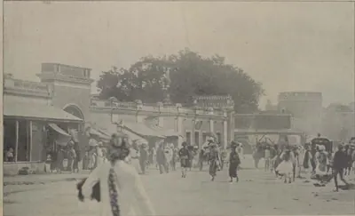 A busy main street of Hyderabad, with people walking and buildings on each side.