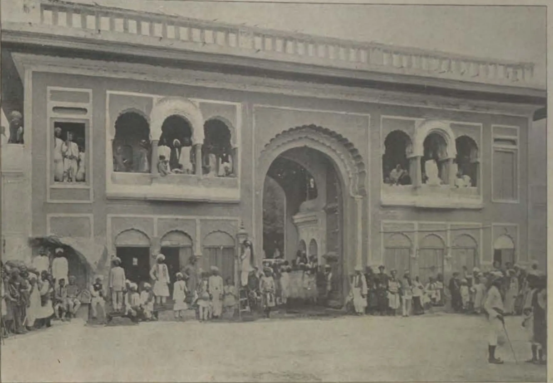 The north gateway of the Salar Jung palace, an arched gate with balconies crowded with people.