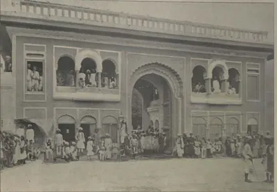 The north gateway of the Salar Jung palace, an arched gate with balconies crowded with people.