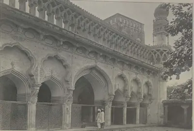 The Jami Masjid of Hyderabad, an arcade of cusped arches with a minaret behind.