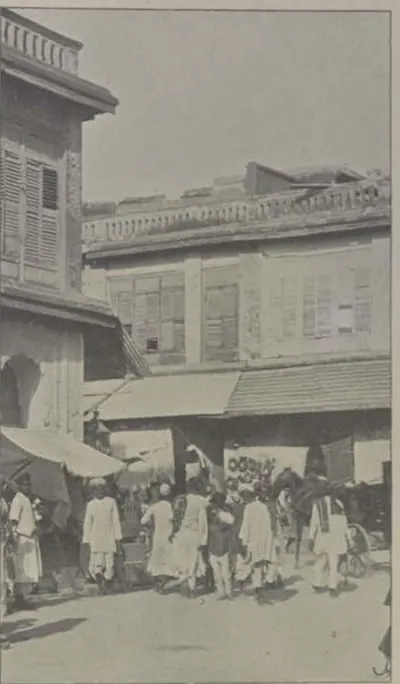 A street of tall houses with a crowd of people.