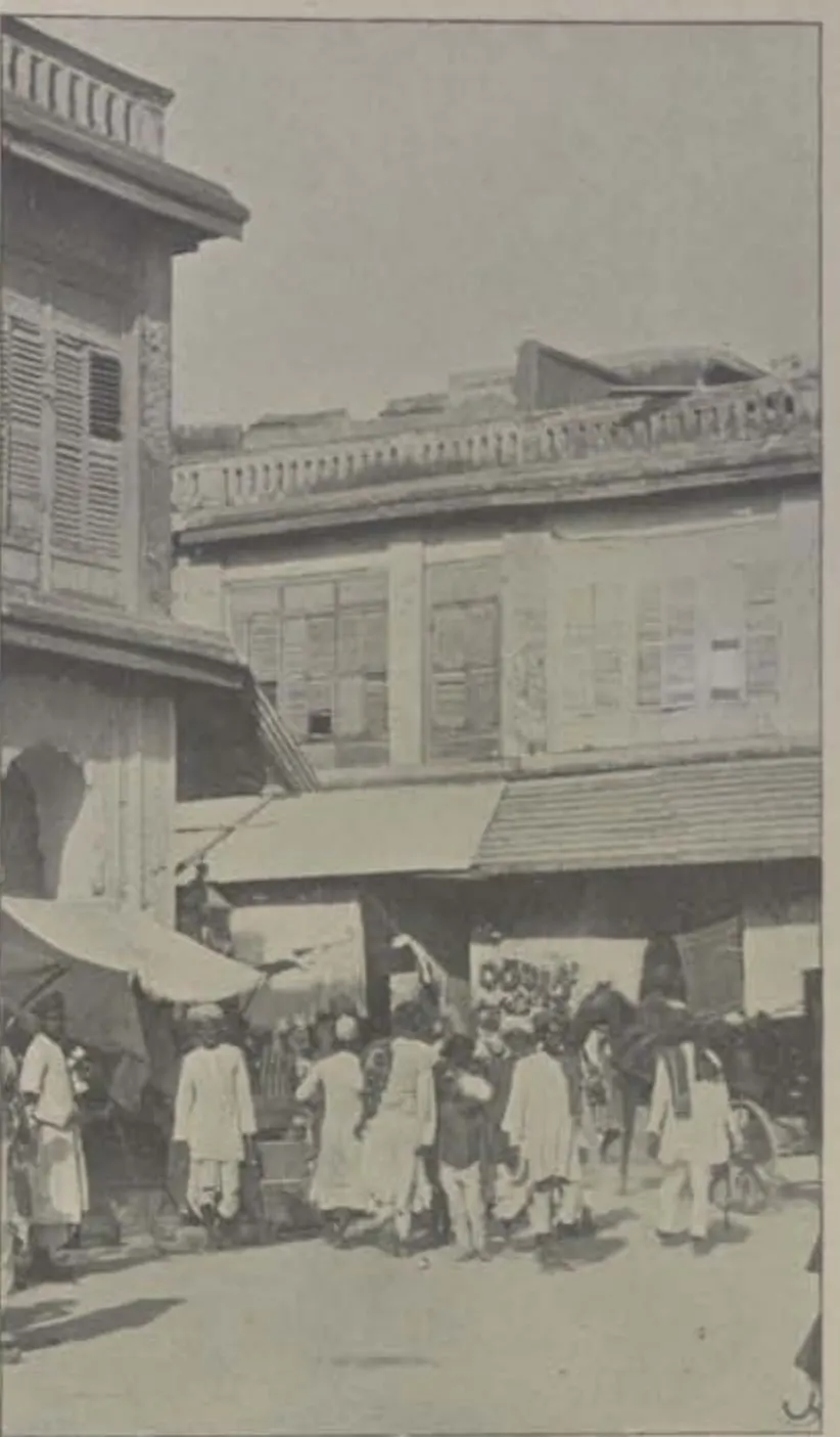 A street of tall houses with a crowd of people.