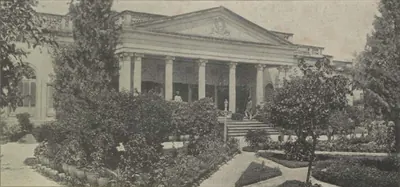 A classical palace front with columns, seen behind a garden.