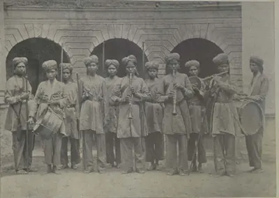A line of women guards in uniform in front of an arcade, some holding a drum and musical instruments.