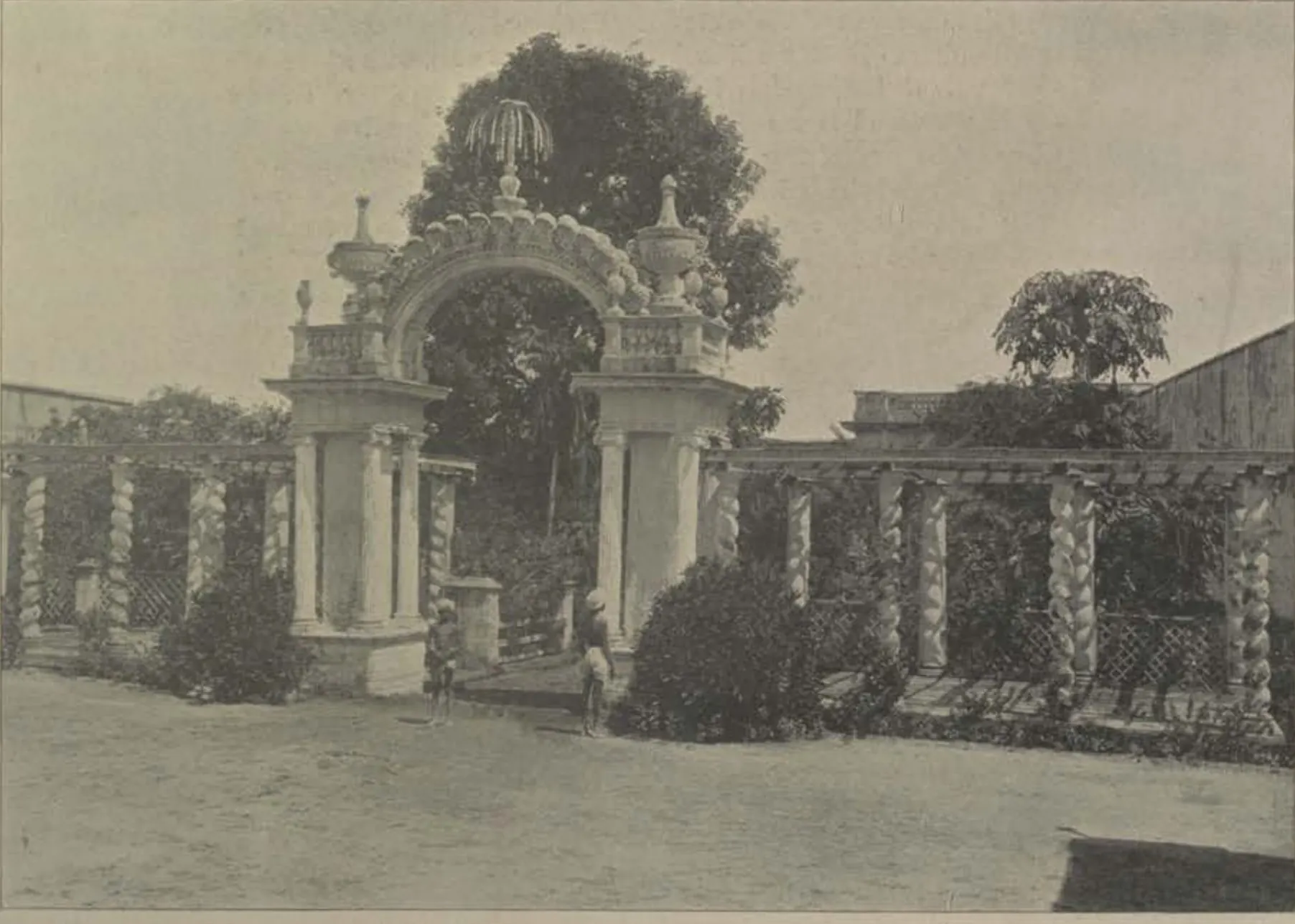 An ornamental arched gateway in a trellised garden.