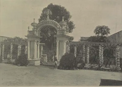 An ornamental arched gateway in a trellised garden.
