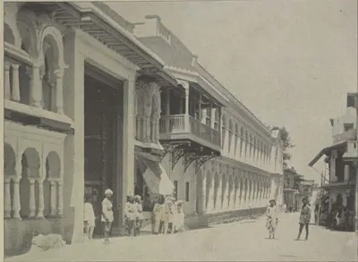 A long many-storeyed palace with balconies along a street.