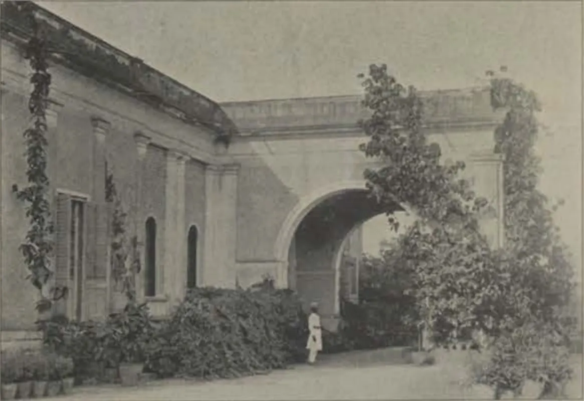 A house with an arched gateway and creepers.
