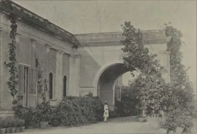 A house with an arched gateway and creepers.