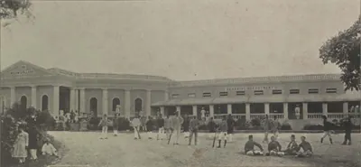 The Nizam College, a long single-storeyed building, with a group of people in front.