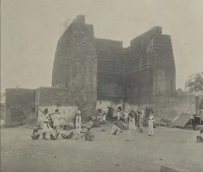 The ruined walls of Raymond's gun foundry, with people in front.