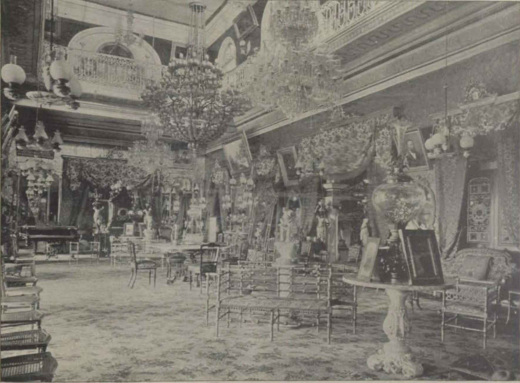 The reception room of the Bashir Bagh palace, crowded with furniture under chandeliers.