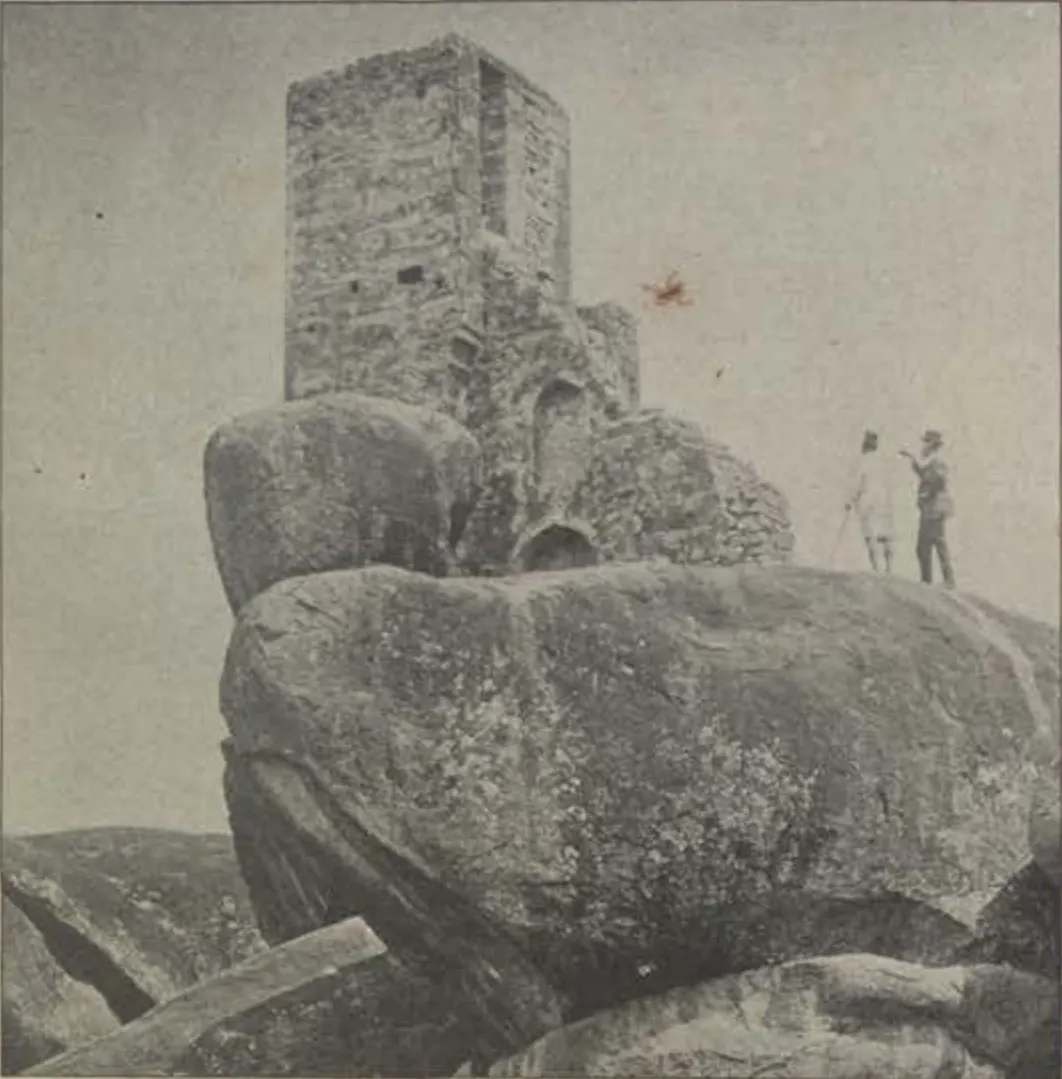 Tipu's look-out, a square tower on huge boulders, with two men standing beside it.