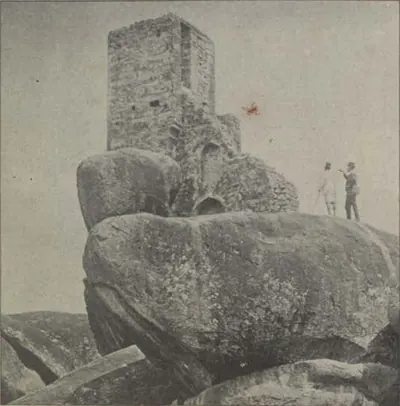 Tipu's look-out, a square tower on huge boulders, with two men standing beside it.