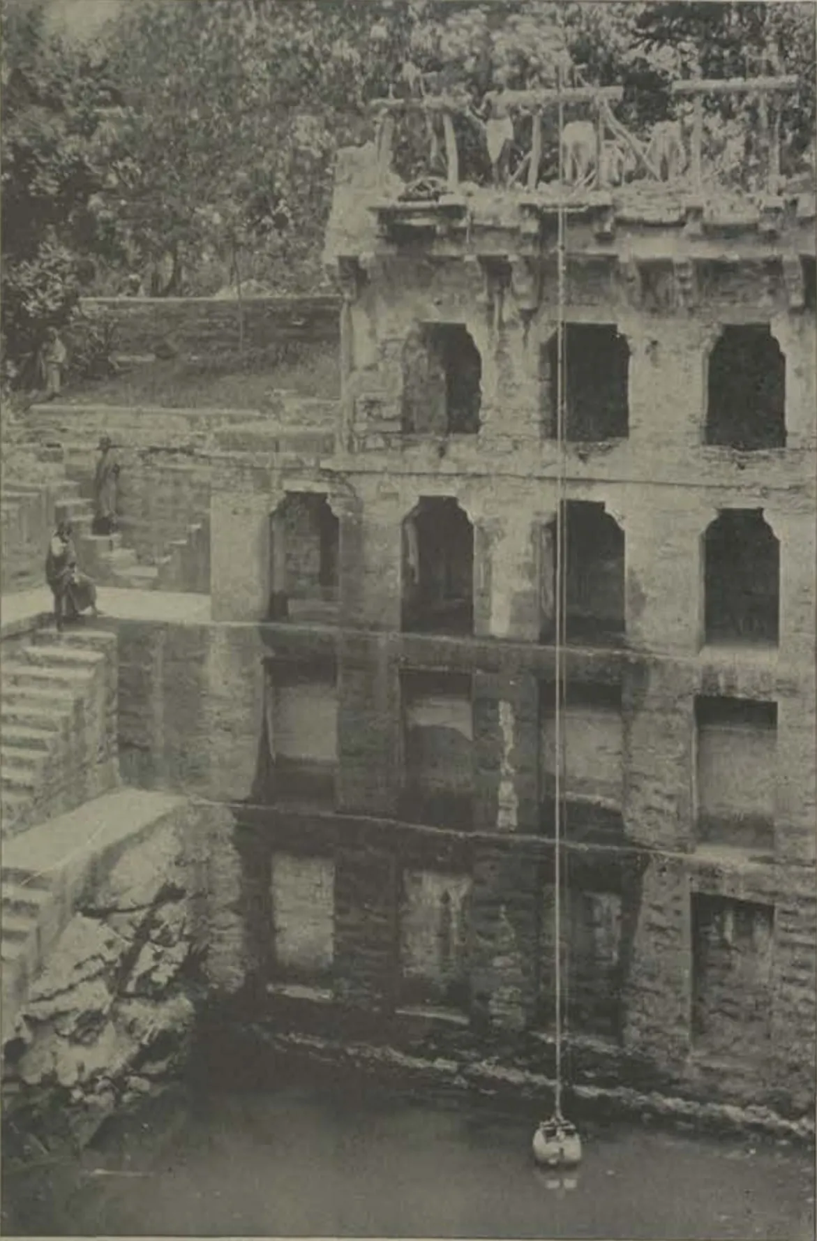 A deep stepped well with tiers of arched galleries.
