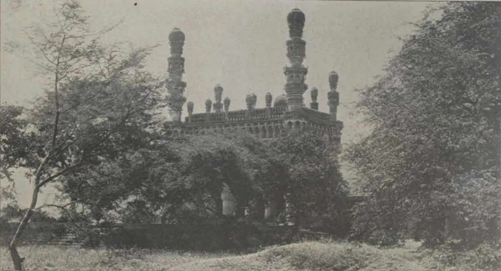 The Toli Masjid at Karwan, with its minarets, seen among trees.