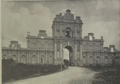 The gateway of the Falaknuma palace, a tall ornate arch with a road through it.