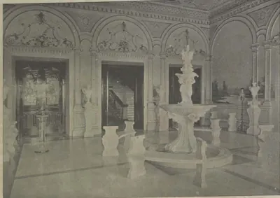 The vestibule of the Falaknuma palace, a marble hall with a fountain and statues.