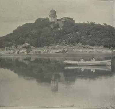 A domed tomb on a hill above the Mir Alam lake, with a boat on the water.