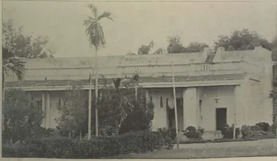 A single-storeyed palace building with palms in front.