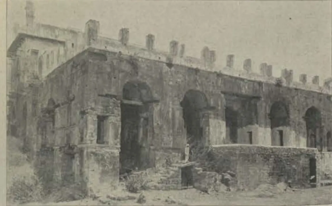 Ruins of the king's palace, a long arcaded building with a crenellated top.