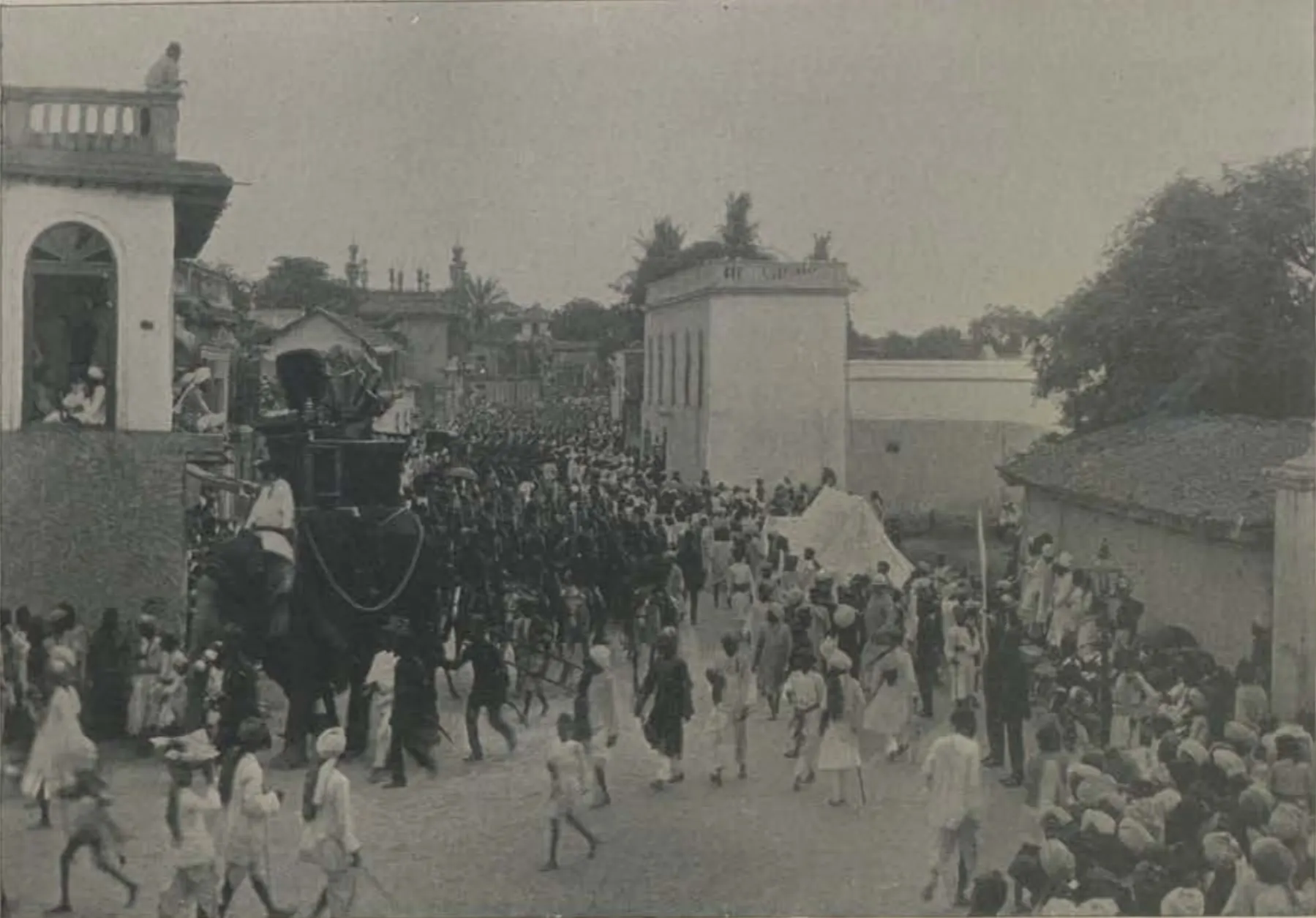 A crowded street procession with mounted police and an elephant.