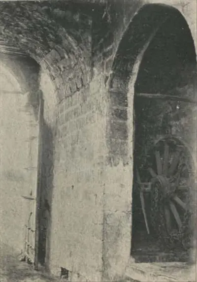 An arched gateway passage of the Juctial fort, with a cart wheel inside.