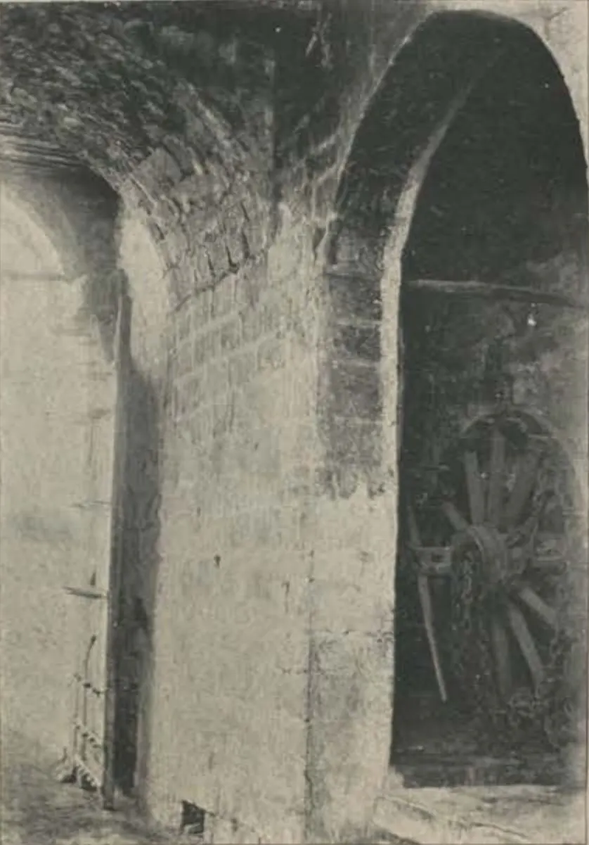 An arched gateway passage of the Juctial fort, with a cart wheel inside.