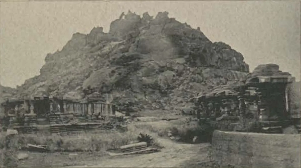 Ruined temples at the foot of a rocky hill.