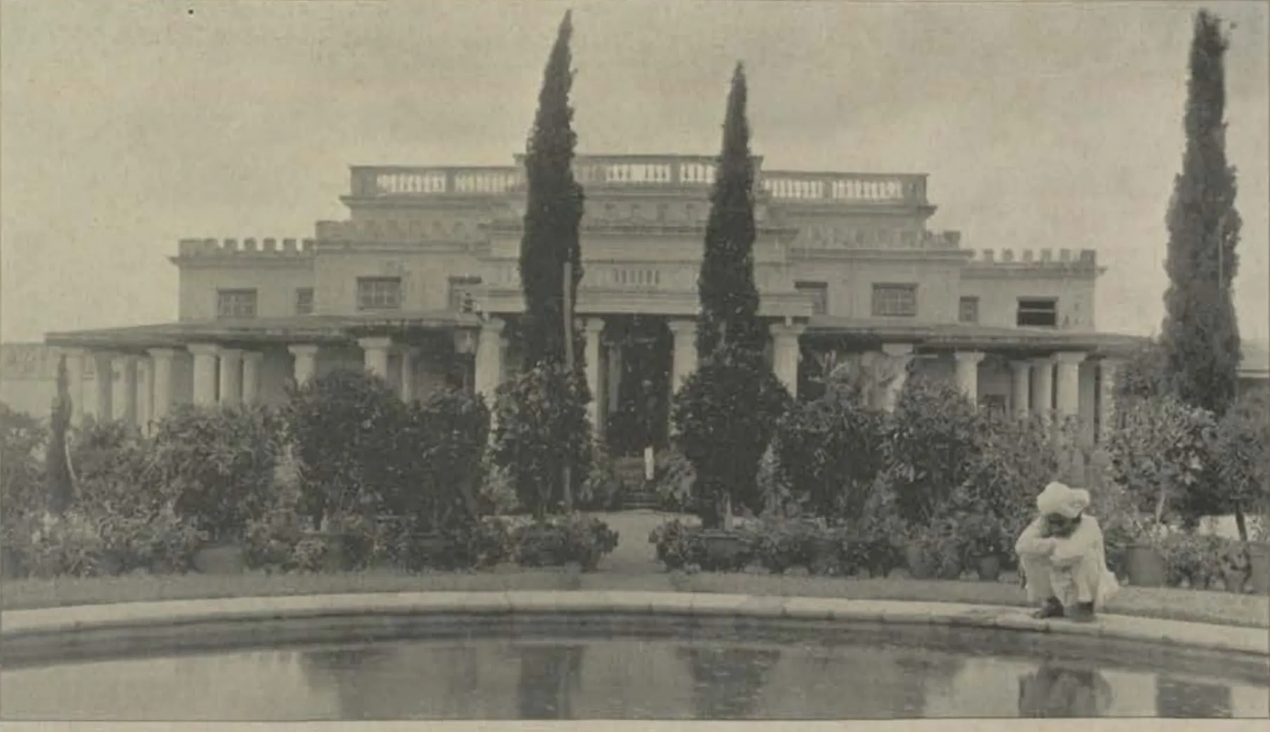 The Subadar's residence, a house with cypress trees behind a pool.